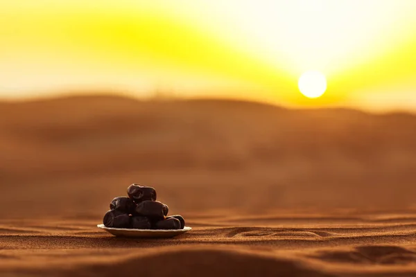 Datle na nádherné desce v poušti v nádherném zapadajícím slunci, symbolizující Ramadan — Stock fotografie