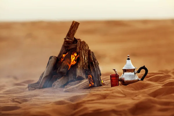 Datle, čajník, šálek čaje u ohně v poušti s nádherným pozadím — Stock fotografie