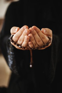 Tespih tutan bir kadının dua elleri