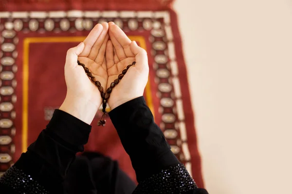 Mãos de oração de uma mulher segurando um rosário, com espaço para texto — Fotografia de Stock