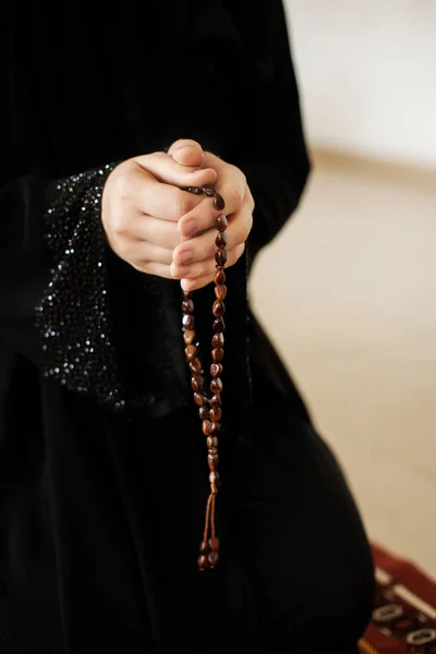 Mãos de oração de uma mulher segurando um rosário — Fotografia de Stock