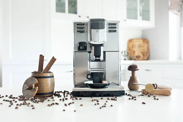 Natureza morta com máquina de café caseira na mesa da cozinha com recipiente de madeira com grãos de café . — Fotografia de Stock