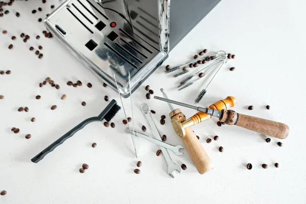 Ferramentas para reparar máquinas de café close-up. Grãos de café, placa de madeira, máquina de café, mesa de cozinha — Fotografia de Stock