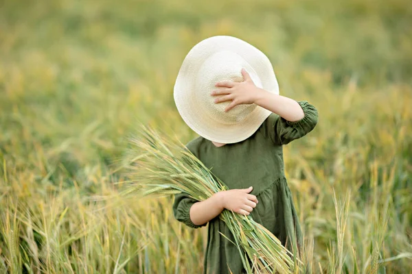 金色の小麦の中を歩く幸せな女の子は フィールドでの生活を楽しんでいます 自然の美しさと小麦の畑 家族のアウトドアライフスタイル 自由の概念 夏のフィールドでかわいい女の子 — ストック写真