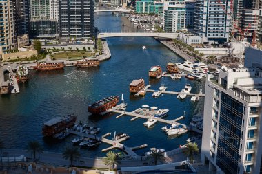 Dubai, BAE, Kasım 2019 'da Marina Dubai kanalındaki yatlar konut kuleleri ve gökdelenlerle çevrilidir. Modern şehir manzarası