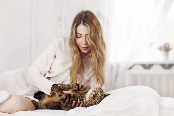 Uma Menina Bonita Brinca Com Seu Gato Fofo Gracioso Cama — Fotografia de Stock