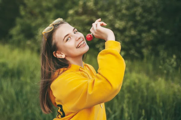 Uma Menina Sorridente Uma Camisola Amarela Brilhante Segura Chupa Chupa — Fotografia de Stock