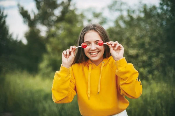 Uma Menina Sorridente Uma Camisola Amarela Brilhante Segura Chupa Chupa — Fotografia de Stock