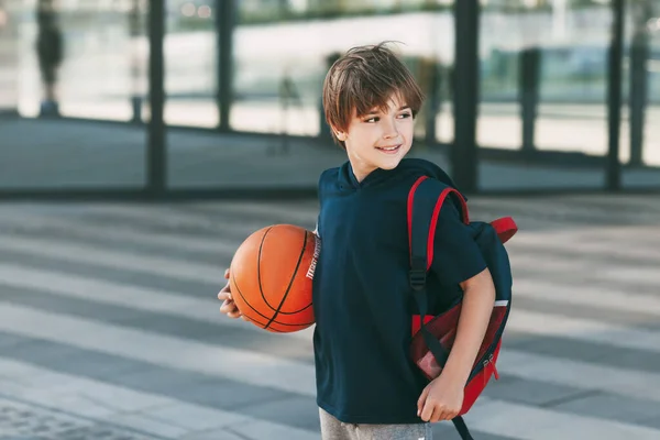 가방과 농구공을 스포츠 유니폼을 아름다운 소년의 소년은 미소를 지으며 잡는다 — 스톡 사진
