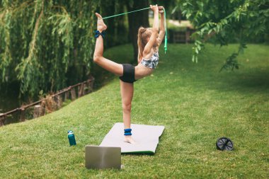 Genç bir kız, karantina sırasında evinin yakınında spor oyunları oynuyor. Spor yapmak.