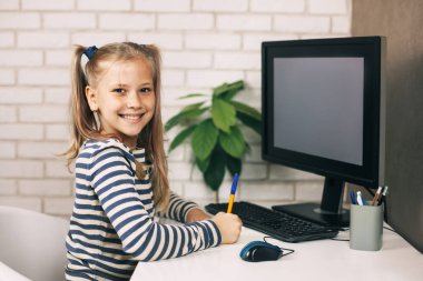 Mutlu liseli kız ödev yapıyor masada oturuyor, genç kız internetten öğrenme konusunda mutlu. Modern eğitim ve bilgi kavramı. Kapat.