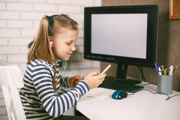 Girl Headphones Phone Her Hands Sits Home Table Computer Does — Stock Photo, Image