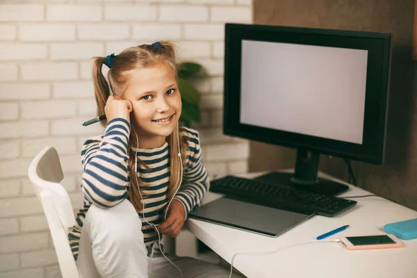 Una Colegiala Con Auriculares Sienta Una Mesa Cerca Una Computadora —  Fotos de Stock