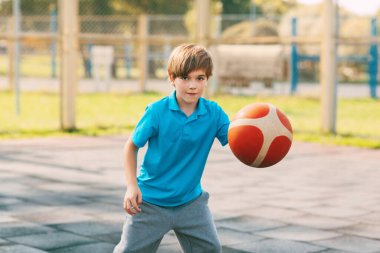 Odaklanmış yakışıklı sporcu çocuk basketbol maçında topa öncülük ediyor. Okuldan sonra bir çocuk basketbol oynar. Spor, sağlıklı yaşam tarzı.
