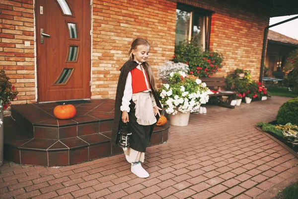 Κοριτσάκι ντυμένο σαν νεράιδα με ένα φανάρι κατά τη διάρκεια του εορτασμού του Halloween πηγαίνει να επισκεφθεί για λιχουδιές — Φωτογραφία Αρχείου