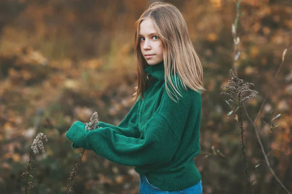 Retrato de uma linda adolescente com cabelo loiro e olhos azuis em um parque de outono. Crianças no parque de outono — Fotografia de Stock