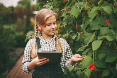 Küçük bir kız araştırmasını bir tablete yazarak doğayı keşfediyor. Meraklı çocuklar. Ekoloji