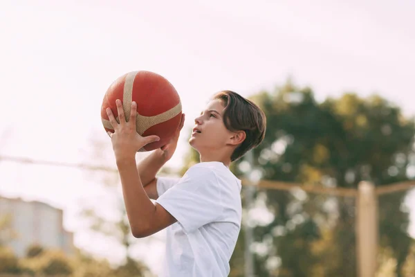 Close-up dari tangan atlet muda memegang bola basket. Atlet bersiap untuk melempar. Olahraga, atlet, gaya hidup sehat — Stok Foto