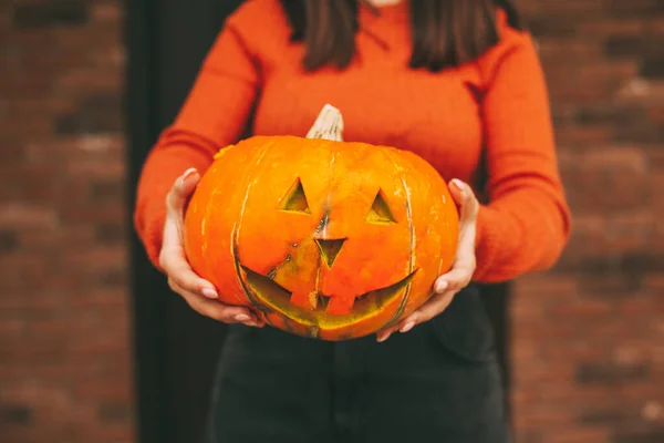 Большая тыква в руках девушки на Хэллоуин. Крупный план. — стоковое фото
