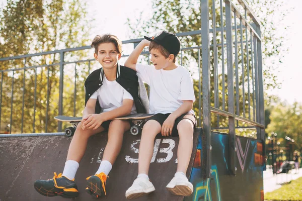 Remaja menikmati waktu luang mereka di skate Park, duduk di lereng. Konsep pemuda, persatuan dan persahabatan — Stok Foto