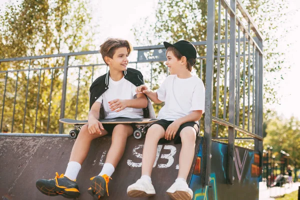 Remaja menikmati waktu luang mereka di skate Park, duduk di lereng. Konsep pemuda, persatuan dan persahabatan — Stok Foto