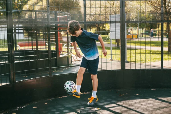 스 포오 츠 제복을 입은 한 젊은이가 프리스타일 축구 코트에서 공을 가지고 열차를 타고 있다. 축구 선수는 공을 가지고 경기를 한다. 스포츠, 여가, 훈련, 프리스타일 — 스톡 사진