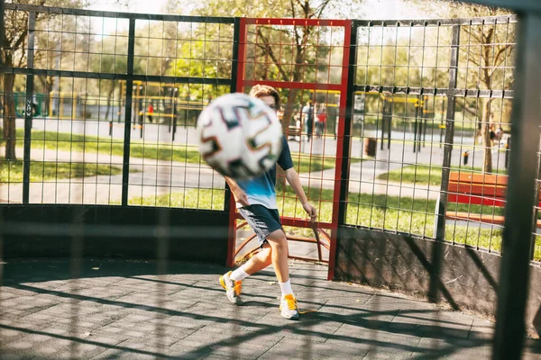 Bola terbang close-up di daerah gaya bebas. Pemain sepak bola bermain dengan bola. Olahraga, rekreasi, pelatihan, gaya bebas — Stok Foto