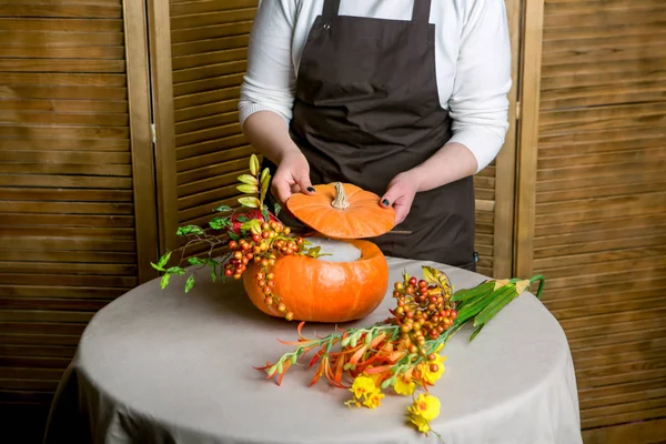 Florist at work: How to make a Thanksgiving centerpiece with big pumpkin and bouquet of flowers. Step by step, tutorial.