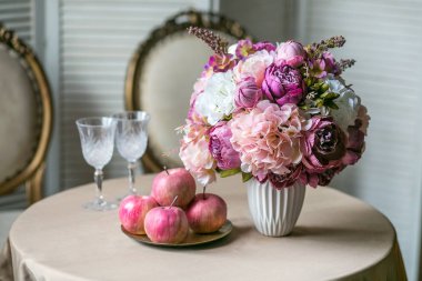 Yemek Masası Klasik sandalyeleri, ortanca ve peonies bir vazo, şarap, gözlük ve elma bir buket