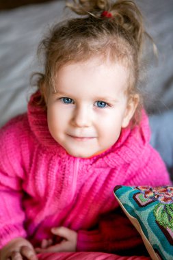 mavi gözlü sevimli kız pembe ceket kameraya benziyor