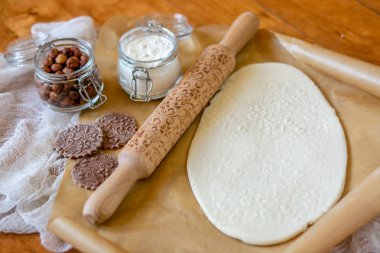 Oklava ile dekore edilmiş ahşap bir masa üzerinde bir desen ile pişmiş un kaplı. Bir desen ve çerez çeşitli şekiller ile rulo hamur. Arka plan, yakın çekim yemek bisküvi.