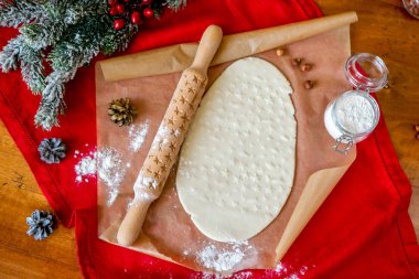 Oklava ile dekore edilmiş ahşap bir masa üzerinde bir desen ile pişmiş un kaplı. Bir desen ve çerez çeşitli şekiller ile rulo hamur. Arka plan, yakın çekim yemek bisküvi.