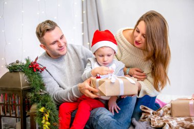 Mutlu aile, Baba, anne ve oğlu, yatak odasında sabah Noel için dekore edilmiştir. Hediyeleri açabilir ve eğlenin. Yeni yıl ve Noel Tema. Tatil ruh hali.