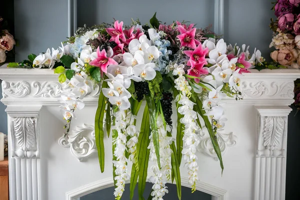 Bouquet of beautiful mixed flowers in vase on the fireplace. Lovely bunch of flowers. Work of the professional florist. Wedding or home decor