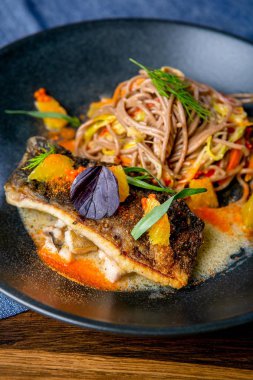 Buğday noodle wok ve pişmiş sazan. Asya mutfağı. Bir profesyonel şef eseri. Bir restoran veya kafe menüsünden çanağı. Yakın çekim