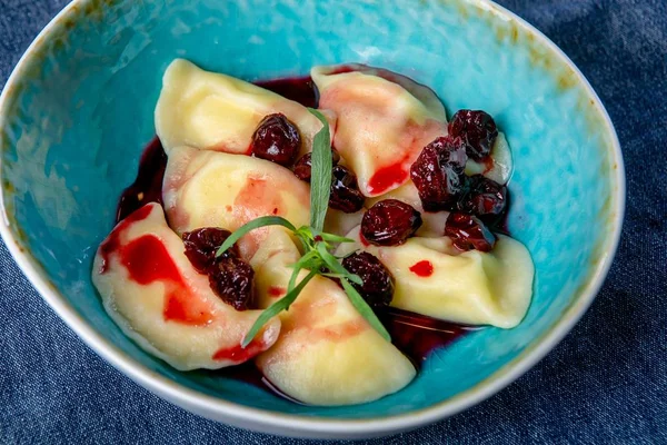 Cherry dumplings. Russian cuisine. The work of a professional chef. Dish from a restaurant or cafe menu. Close-up