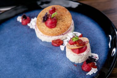 Yoğurt ve ahududu kremalı beyaz çikolatalı mus. Fransız mutfağı. Profesyonel bir şefin işi. Restoran ya da kafe menüsünden bir tabak. Yakın plan.