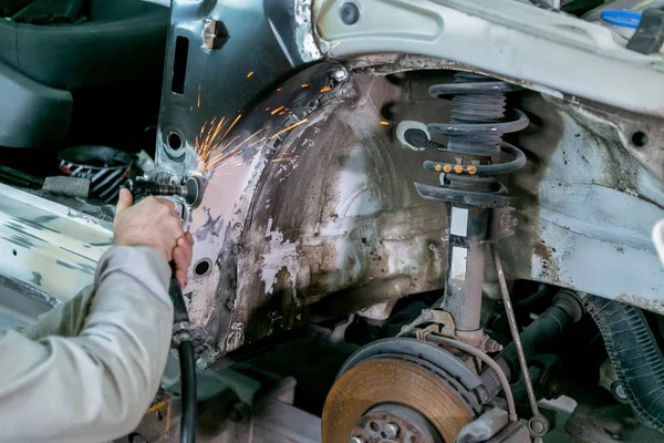 Araba servisinde araba tamiri. Tamirci işçi tamircisi zımparalama araç gövdesi ve onarım sırasında boyama için otomobil hazırlama ve servis istasyonu dükkanında yenileme — Stok fotoğraf