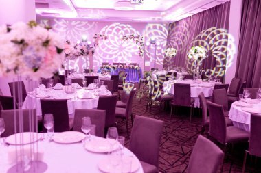 Mavi ve beyaz tonlarda düğün ziyafeti. Bir parti, düğün resepsiyon veya diğer festival olay için yüksek bir kök üzerinde bir vazo tabak ve beyaz çiçek düzenlemeleri ile güzel masa ayarı