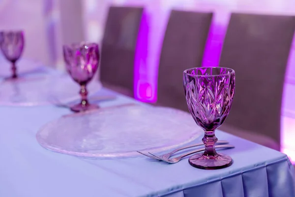 Beautiful table setting with crockery for a party, wedding reception or other festive event. Glassware and cutlery for catered event dinner. Horizontal photo