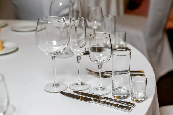 Beautiful table setting with crockery for a party, wedding reception or other festive event. Empty glassware and cutlery for catered event dinner. Horizontal photo