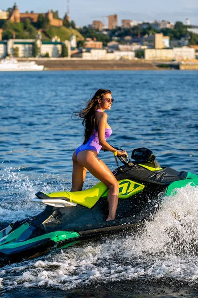 Young sexy girl in a blue swimsuit ride a jet ski on the river in a sunshine. Summer weekend or vacation. Extreme sport — Stock Photo, Image
