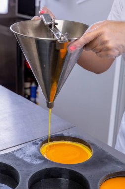 Mutfaktaki pasta şefi tutkulu meyveler yapıyor. Aşçı büyük kalıplara tutku meyvesi döker. Mutfakta master dersi var. Yemek pişirme süreci. Adım adım. Özel ders. Yakın plan.