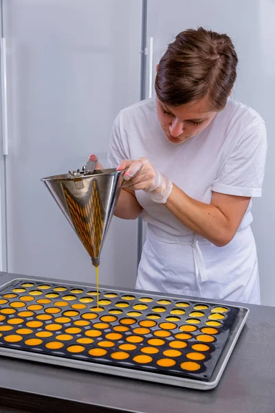 Pastry chef in the kitchen makes passion fruit confit. Cook pours passion fruit confit into the molds. Master class in the kitchen. The process of cooking. Step by step. Tutorial. Close-up