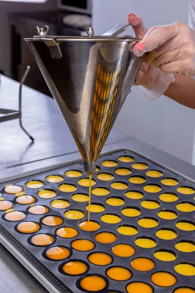 Pastry chef in the kitchen makes passion fruit confit. Cook pours passion fruit confit into the molds. Master class in the kitchen. The process of cooking. Step by step. Tutorial. Close-up