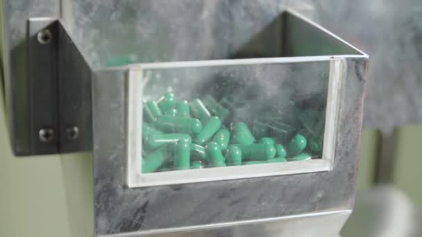 Bewegende lege tweedelige blauw-groene capsules, hard. — Stockvideo