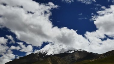 Karlı tepe ve mavi gökyüzü bulutlu Himalaya Dağları Tibet'te