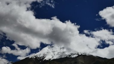 Karlı tepe ve mavi gökyüzü bulutlu Himalaya Dağları Tibet'te