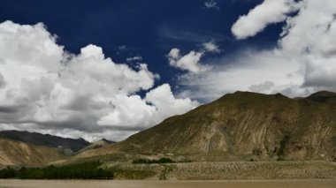 Karlı tepe ve mavi gökyüzü bulutlu Himalaya Dağları Tibet'te