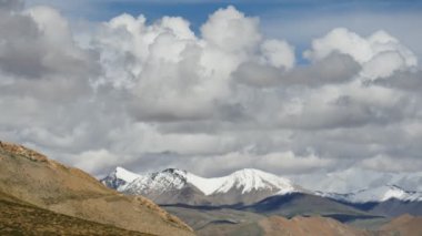 Karlı tepe ve mavi gökyüzü bulutlu Himalaya Dağları Tibet'te